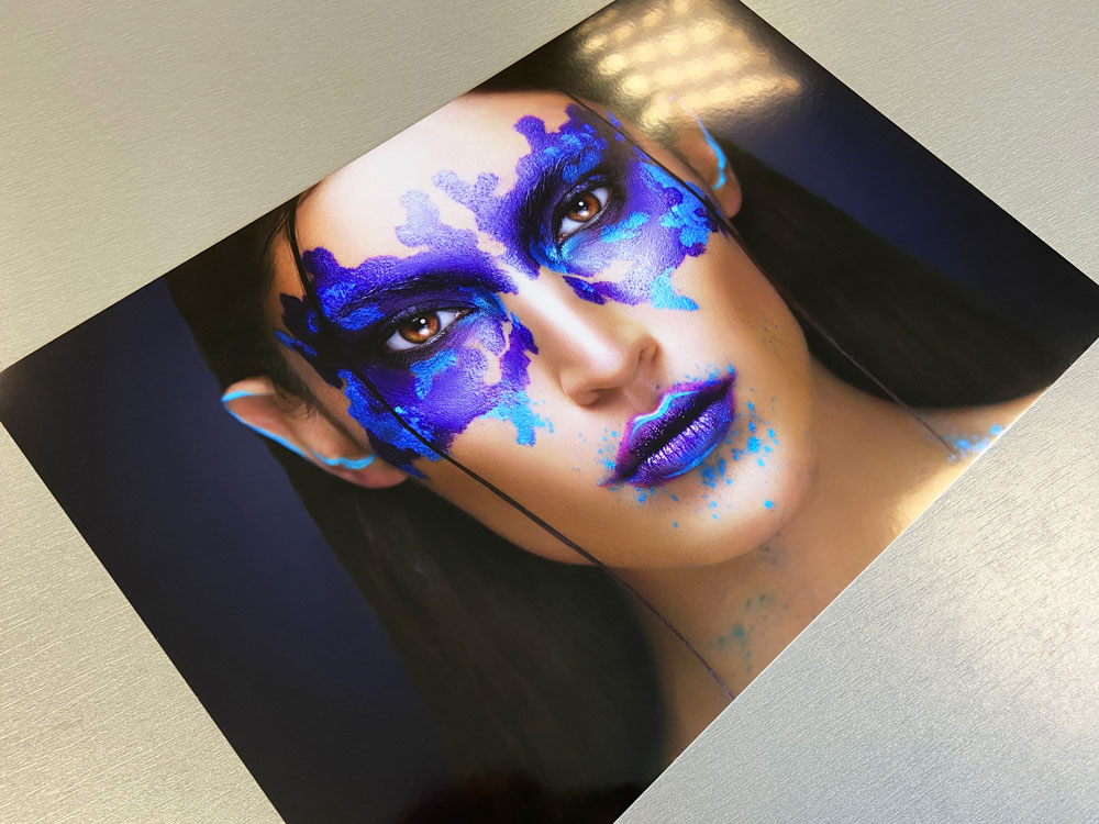 A glossy print of a woman with purple and blue makeup