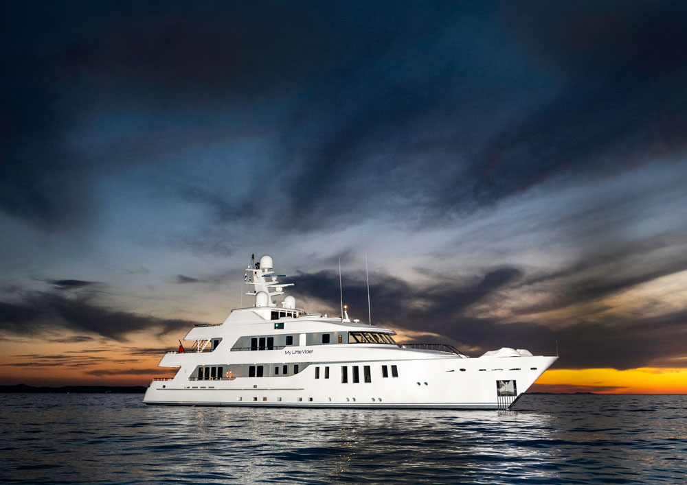 An image of a yacht in front of a sunset